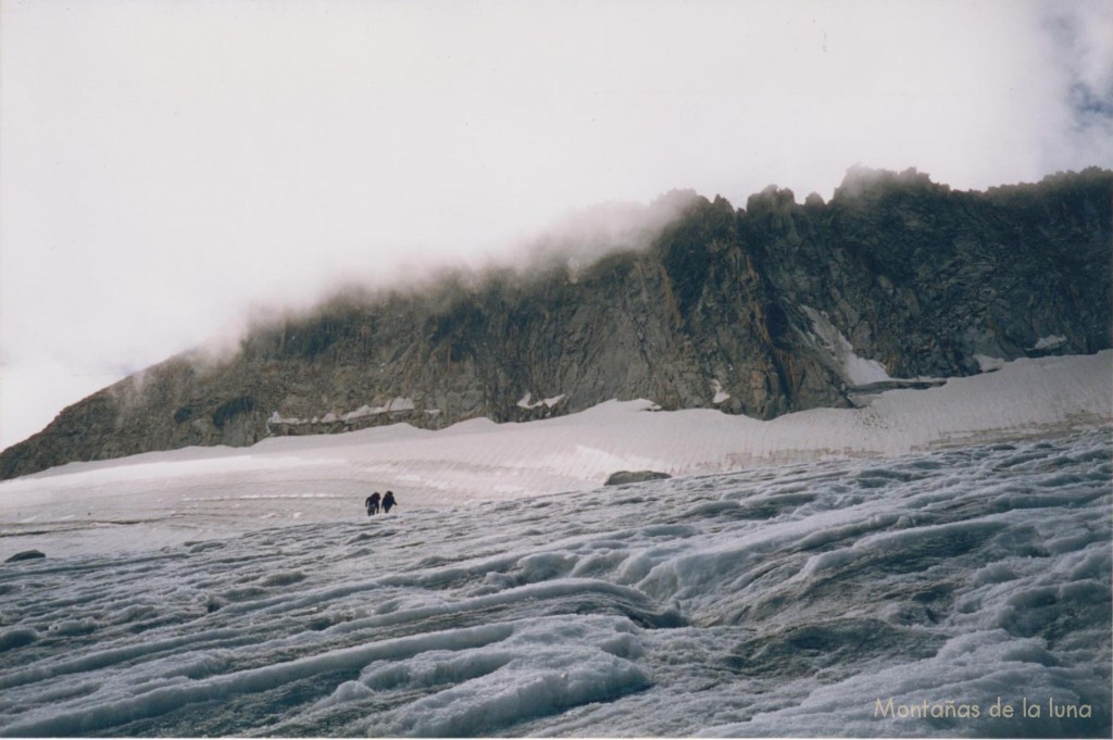 Cruzando el Glaciar del Aneto, arriba entre nubes la Punta d'Astorg en el centro derecha y el Pico de Enmedio más cubierto a la izquierda